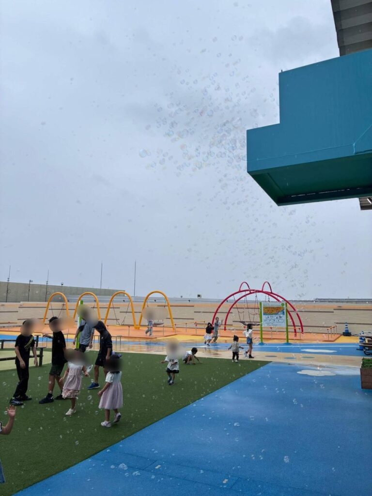 屋上広場のシャボン玉イベントで雨に濡れる子ども