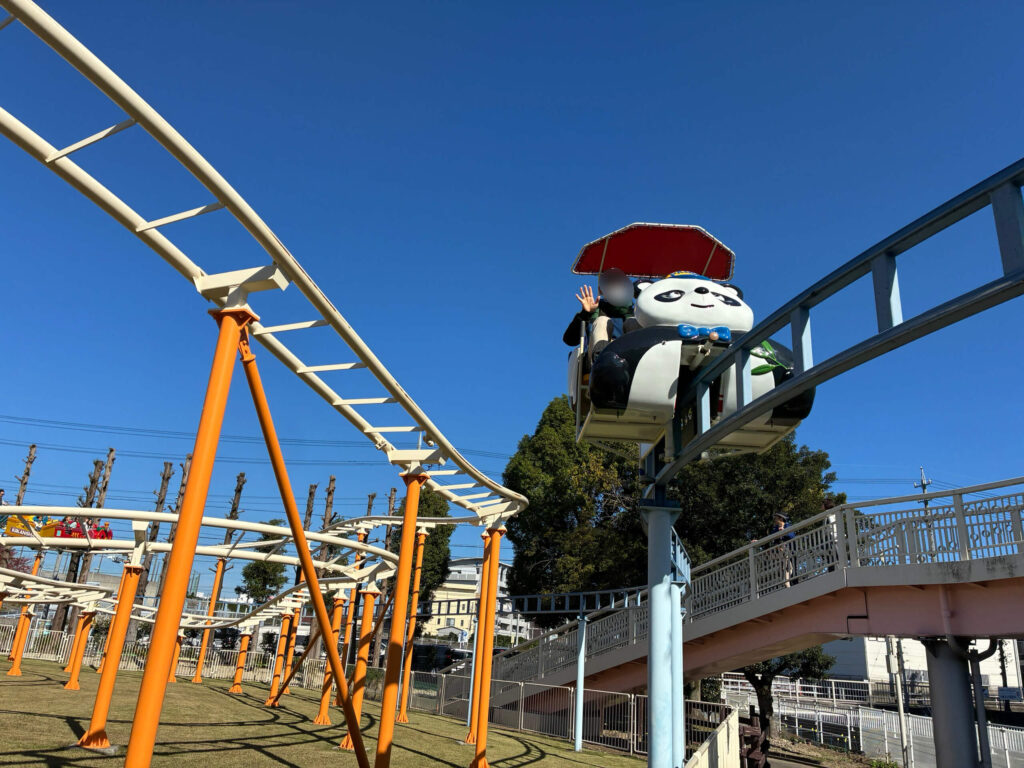 サイクルモノレールに乗って手を振るパパ