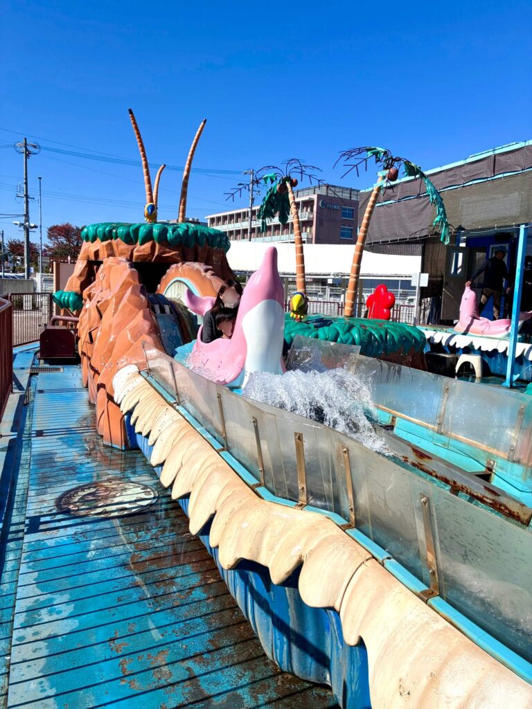 ドルフィンパラダイスというアトラクション乗り物に乗るママと息子