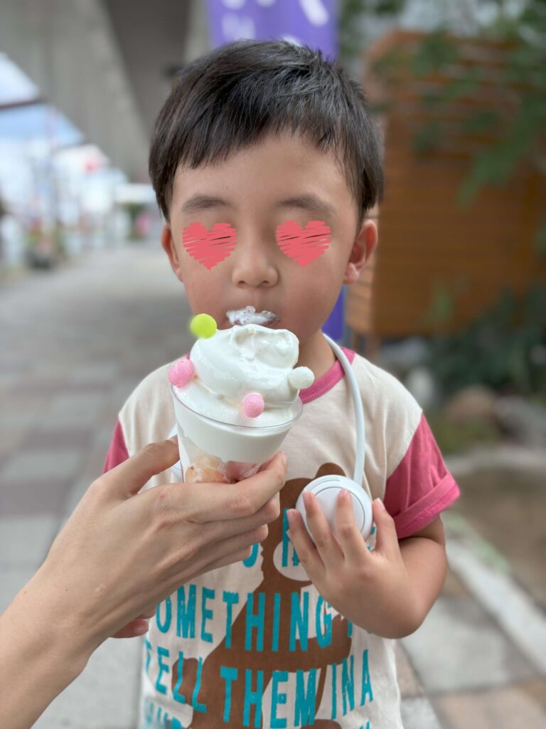 外でソフトクリームを食べている４歳のこども