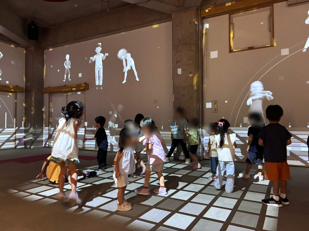 プロジェクションマッピングで映し出される画像で踊る子ども