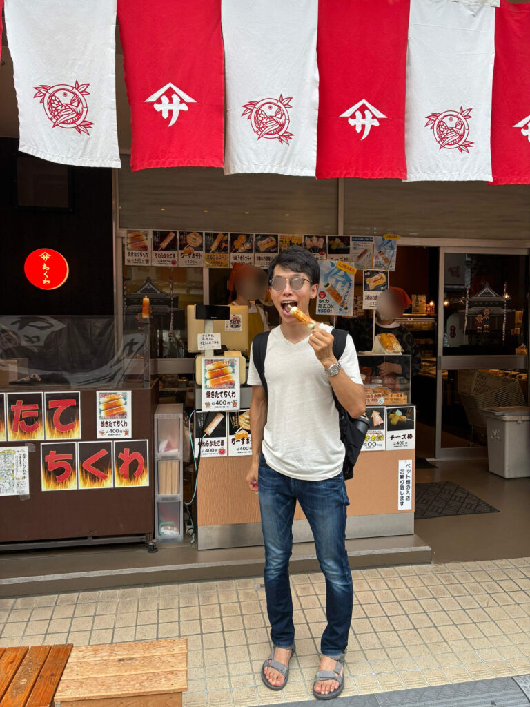 焼き立てちくわを食べている30代男性