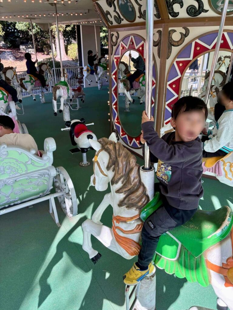 堀内公園のメリーゴーランドに乗る息子