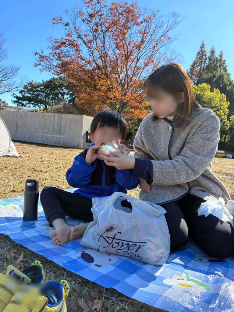 堀内公園内の芝生でランチするママと息子