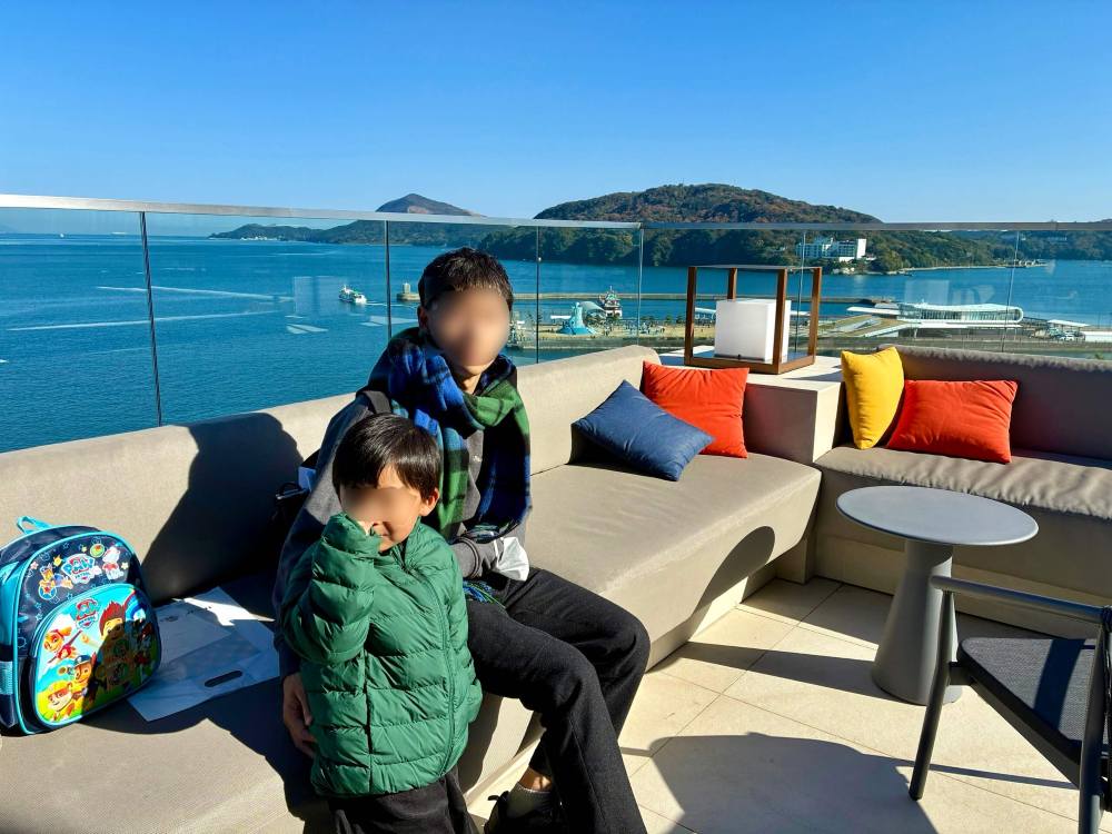 鳥羽国際ホテル内で海を見るパパと子ども
