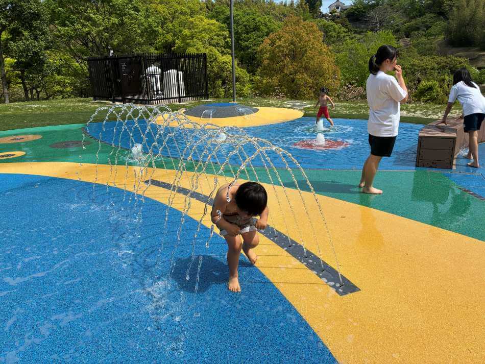 於大公園の水浴び広場で水遊びする子ども